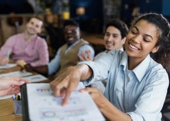 Equipe diversa participando de treinamento corporativo demonstrando colaboração e aprendizado.