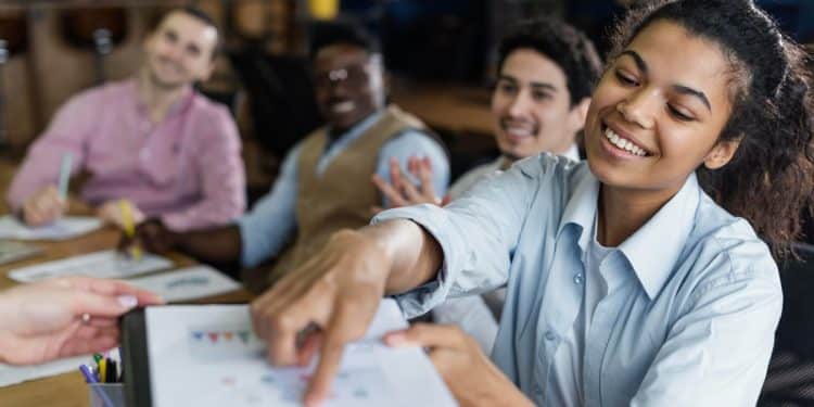Equipe diversa participando de treinamento corporativo demonstrando colaboração e aprendizado.