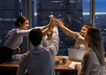 Equipe de trabalho reunida no escritório durante o fim de ano simbolizando profissionais escalados em feriados.