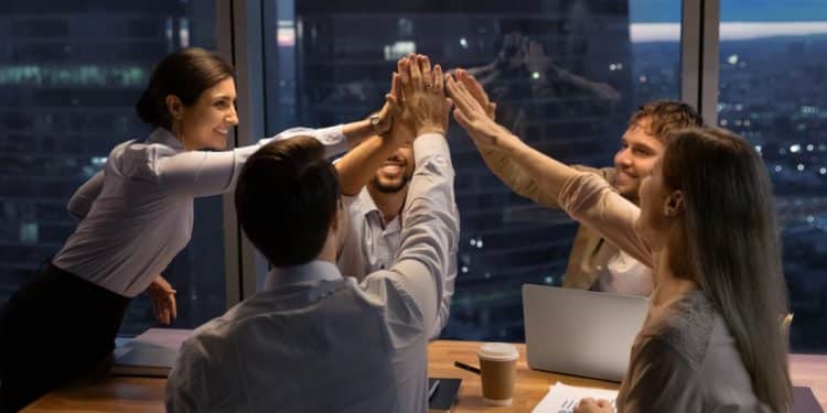 Equipe de trabalho reunida no escritório durante o fim de ano simbolizando profissionais escalados em feriados.