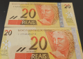 Duas notas de vinte reais (R$ 20) lado a lado, evidenciando as diferentes numerações de série (B e C) e a possibilidade de erros de impressão, como o deslocamento da faixa holográfica, que as tornam itens raros para colecionadores.