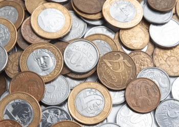 Diversas moedas brasileiras de 1 real, 5 centavos e 10 centavos, representando as moedas raras e comemorativas mais valiosas do Brasil.