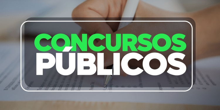 Mão segurando caneta e preenchendo formulário de concurso público com texto destacado concursos públicos.