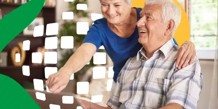 Casal de idosos sorrindo e interagindo com laptop em ambiente doméstico iluminado