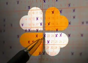 Cartela da Mega da Virada sendo preenchida com caneta, com um trevo de quatro folhas em destaque, representando o tema da sorte e a escolha dos números para a loteria.