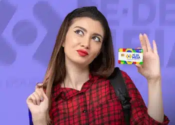 Mulher segurando um cartão do Pé-de-Meia com um fundo colorido e o logotipo visível.