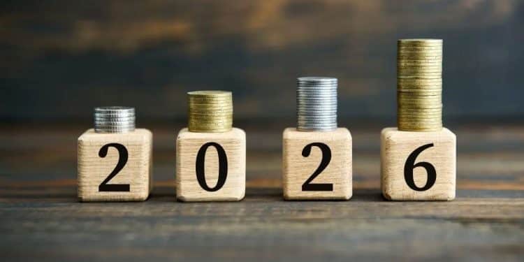 Quatro blocos de madeira formando o ano 2026 com pilhas de moedas crescentes sobre cada um.