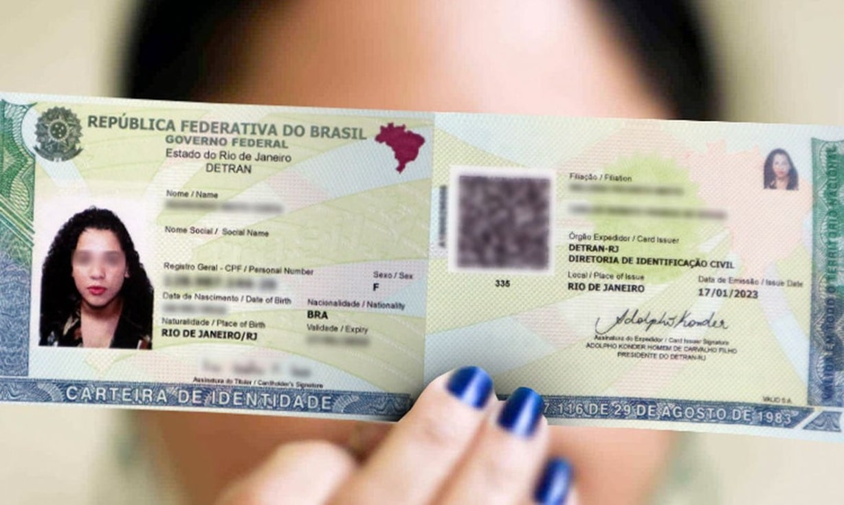 Pessoa segurando carteira de identidade do Rio de Janeiro com foto e dados pessoais visíveis.