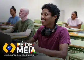 Aluno do ensino médio assistindo aula presencialmente com headphones.