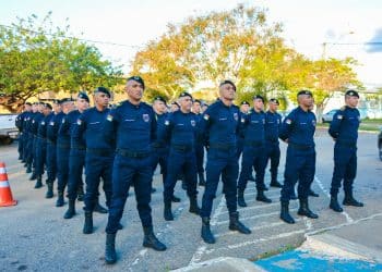 Grupo de guardas municipais uniformizados alinhados em formação durante evento ao ar livre
