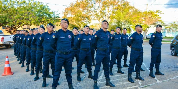 Grupo de guardas municipais uniformizados alinhados em formação durante evento ao ar livre