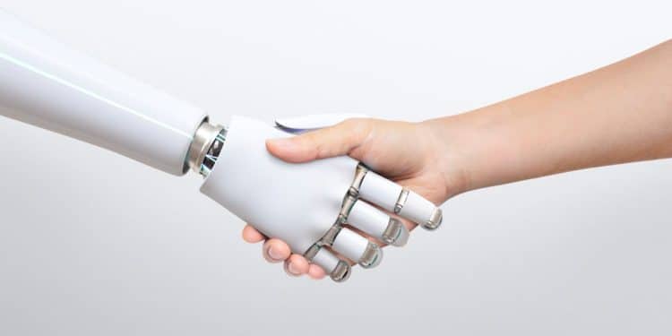 Aperto de mão entre uma mão humana e um braço robótico branco, simbolizando a parceria entre humanos e Inteligência Artificial (IA) no mercado de trabalho e as profissões impulsionadas pela tecnologia.