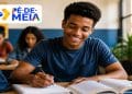 Estudante sorrindo enquanto escreve em um caderno em sala de aula, ao lado do logo do Pé-de-Meia, programa que paga R$ 200 pela participação no Enem a alunos da EJA