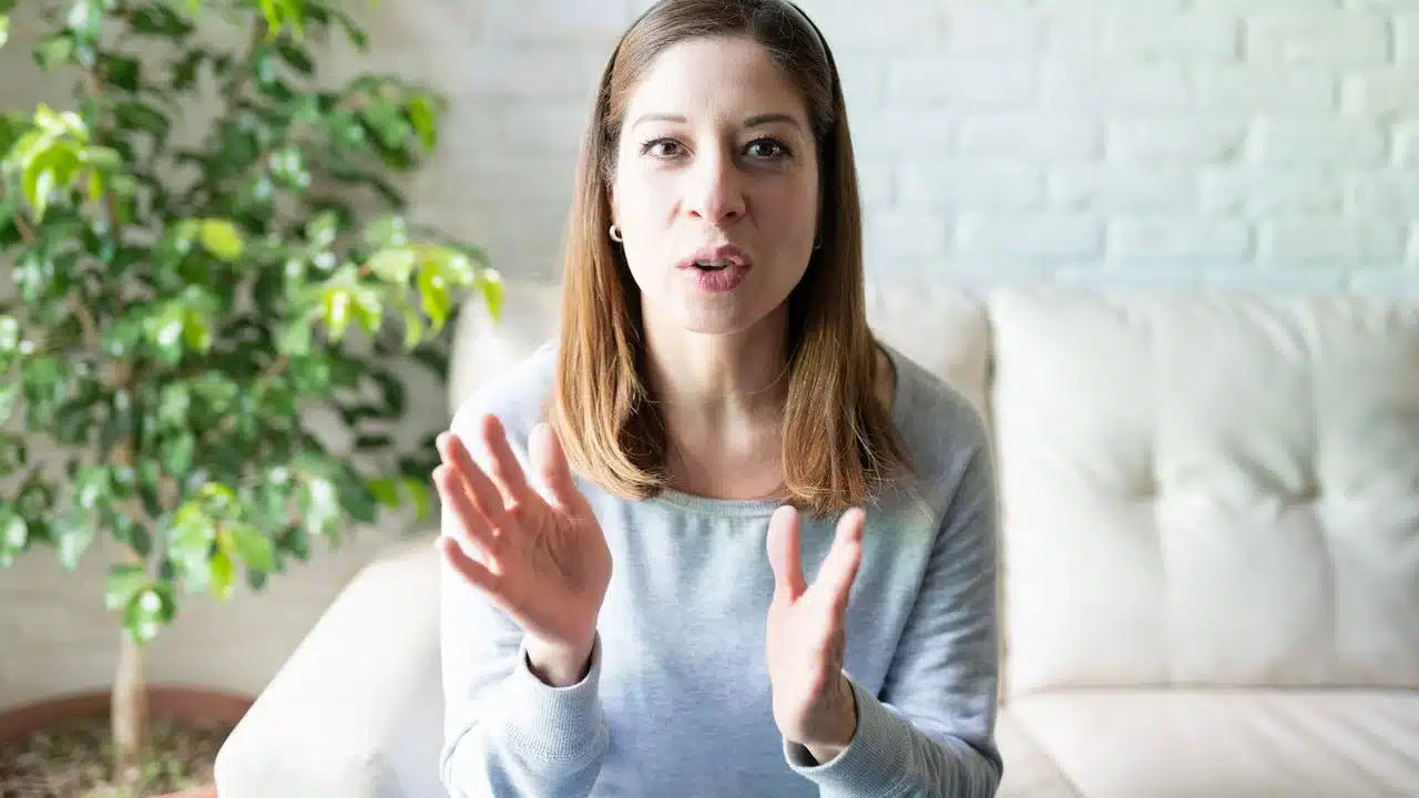 Mulher gesticulando enquanto fala, ilustrando o impacto das palavras no comportamento e nas relações.