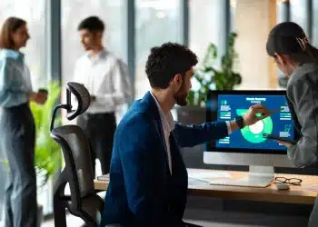 Profissionais discutindo gráficos de tendências de carreiras em escritório moderno.