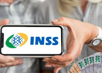 Pessoa segurando um celular com o logo do INSS e cédulas de dinheiro, simbolizando o pagamento do 13º salário do INSS.