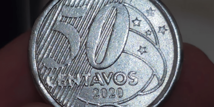 Close-up macro do reverso de uma moeda de 50 centavos de 2020, evidenciando o numeral "50", a inscrição "CENTAVOS" e as estrelas do Cruzeiro do Sul, com foco nas ranhuras do fundo.
