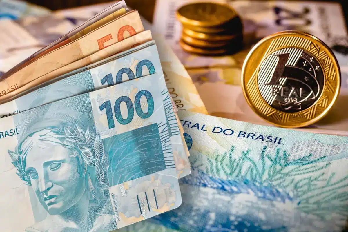 Notas de 100 reais e moedas do Brasil, simbolizando o saque-aniversário do FGTS liberado para trabalhadores nascidos em janeiro desde 2 de janeiro.