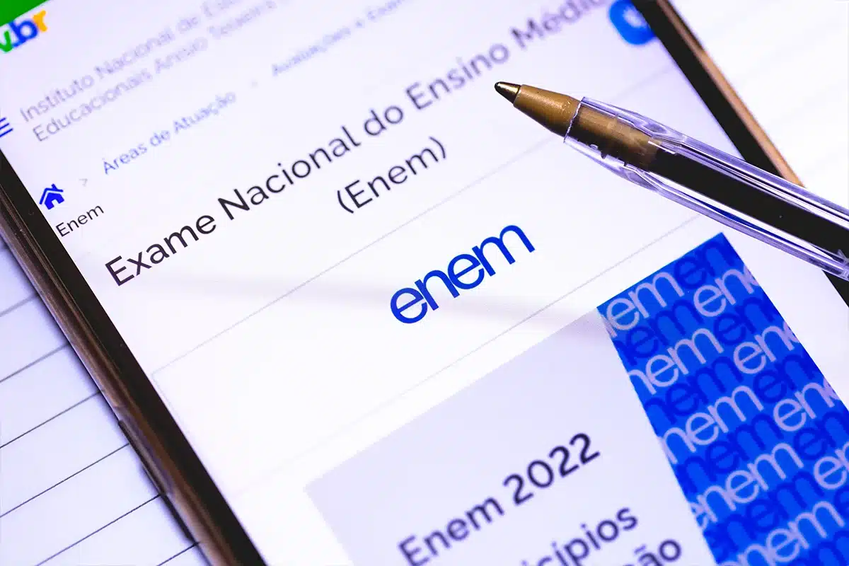 Imagem de um smartphone exibindo a página do Exame Nacional do Ensino Médio (Enem), com foco no logo do Enem e o conteúdo sobre a aplicação das provas em 2025.