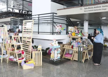 Profissional de fisioterapia realizando massagem em bebê deitado sobre colchão vermelho