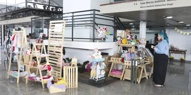 Profissional de fisioterapia realizando massagem em bebê deitado sobre colchão vermelho