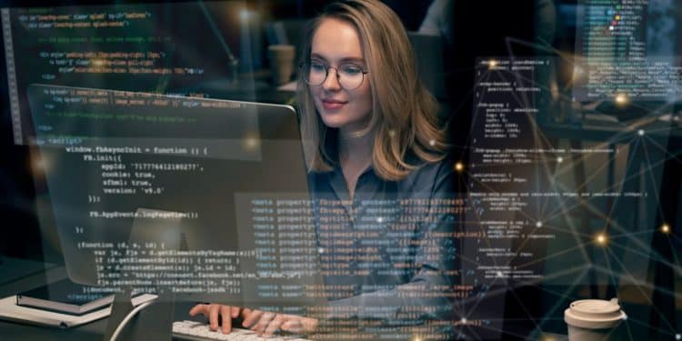 Desenvolvedora trabalhando em computador com linhas de código de programação na tela