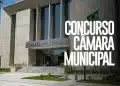 Fachada moderna da Câmara Municipal com bandeira do Brasil e anúncio de concurso público 2026