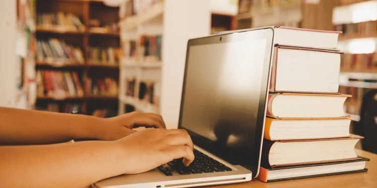 Imagem mostrando um ambiente de estudo com livros e um laptop, representando o contexto de inscrições abertas para processo seletivo e concurso público.