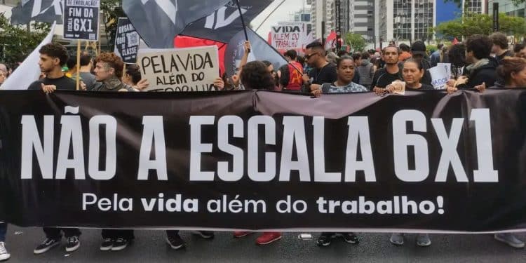 Trabalhadores de diversos setores, como comércio e serviços, segurando cartazes em protesto pelo fim da escala 6x1, com destaque para a demanda por mais tempo de descanso e saúde mental.