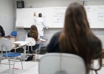 Estudantes assistindo aula em sala de aula, com foco no quadro explicativo, ilustrando os alunos que ingressarão na universidade por meio do Sisu 2026.