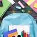 Mochila com materiais escolares coloridos sobre a mesa, representando itens comuns avaliados na lista de material escolar 2026.