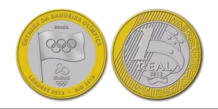 Frente e verso da moeda de 1 real de 2012 da Entrega da Bandeira Olímpica, exibindo o emblema dos cinco anéis e a bandeira no centro.