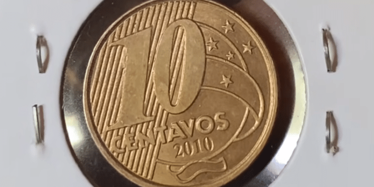 Visão frontal de uma moeda de 10 centavos de 2010, com cor bronzeada, protegida em um suporte de papel branco (coin holder). A imagem foca no numeral "10" e na data "2010" em relevo, evidenciando o brilho metálico e os detalhes da cunhagem.