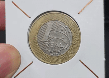 Close-up de uma moeda de 1 real de 1998 Direitos Humanos protegida em um suporte de papel branco para colecionadores.