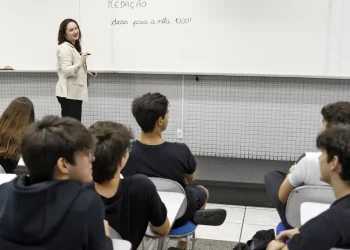 Professora ensinando redação para jovens estudantes em sala de aula