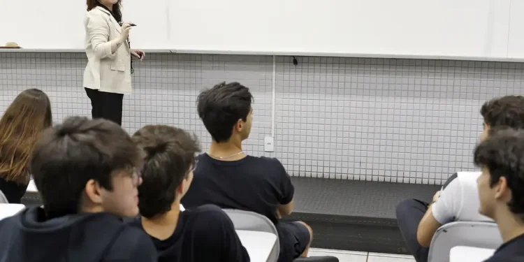 Professora ensinando redação para jovens estudantes em sala de aula
