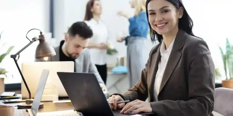 Profissional de escritório trabalhando em frente ao computador, em um ambiente corporativo moderno.
