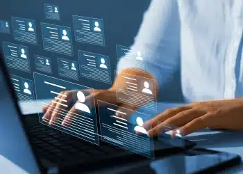 Profissional utiliza computador enquanto perfis digitais representam novas exigências do mercado de trabalho