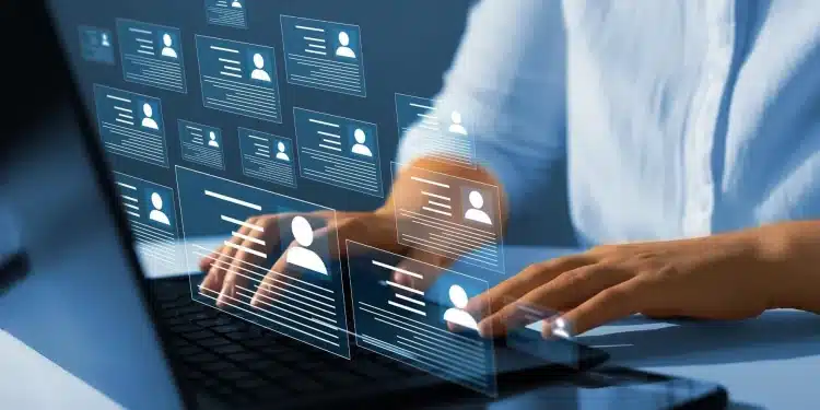 Profissional utiliza computador enquanto perfis digitais representam novas exigências do mercado de trabalho