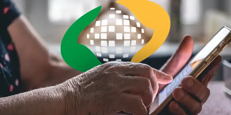 Mãos de idoso utilizando celular para confirmar a prova de vida digital em 2026.