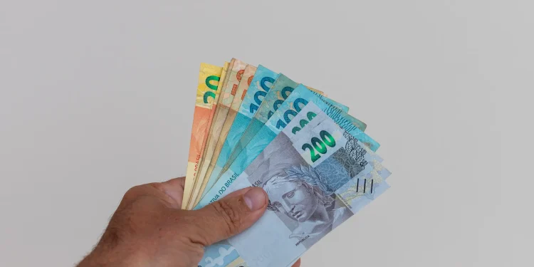 Dinheiro em espécie com notas de R$ 200 e R$ 30, representando a quantia disponível para saque de até R$ 6.220 da Caixa Econômica Federal.