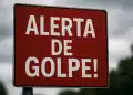 Placa vermelha com os dizeres 'Alerta de golpe!' em branco.