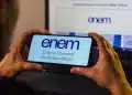 Logo do Enem 2025 exibido em um celular, com a declaração para matrícula na educação superior disponível no site.