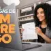 Mulher mexendo no notebook com expressão alegre.