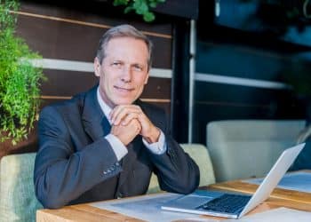 Executivo maduro acima dos 40 anos bem-sucedido com laptop representando carreiras que pagam altos salários pela experiência