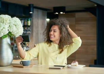 Mulher feliz tirando selfie com expressão confiante representando autoestima e bem-estar emocional
