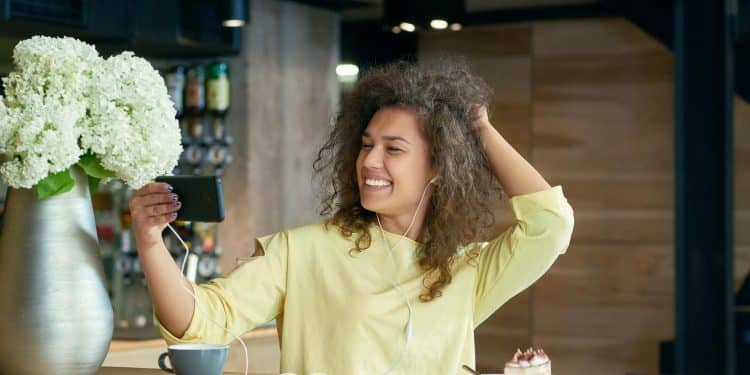 Mulher feliz tirando selfie com expressão confiante representando autoestima e bem-estar emocional