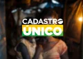 Logotipo do Cadastro Único em destaque, com as cores da bandeira do Brasil (verde, amarelo e branco), sobreposto a uma imagem desfocada de uma mãe e seu filho em um ambiente doméstico humilde.