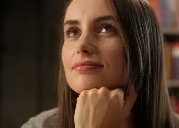 Mulher pensativa refletindo sobre autoconhecimento e identidade pessoal em ambiente interno.