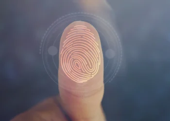 Imagem de um dedo com impressão digital sendo digitalizada para cadastro biométrico, representando as regras de transição na Seguridade Social.